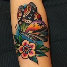 a colorful tattoo on the arm of a woman with flowers and an airplane in the sky