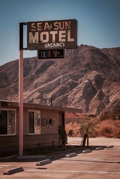 a motel sign in front of a mountain