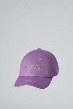 a purple baseball cap with the word arctic on it, hanging from a white wall