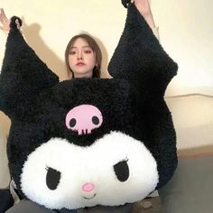 a woman sitting on the floor holding up a large stuffed animal