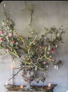 a vase filled with ornaments sitting on top of a wooden table next to a wall