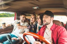 group of people sitting in the back seat of a car