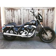 a motorcycle parked in front of a wooden fence