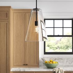 a kitchen with wooden cabinets and a bowl of lemons on the counter next to it