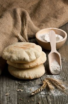 three pita breads stacked on top of each other next to a wooden spoon