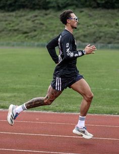 a man running on a track wearing sunglasses