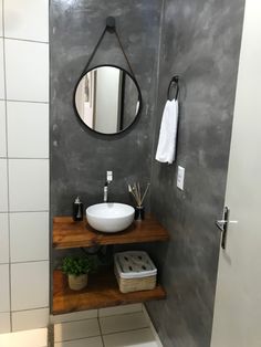 a bathroom with a sink, mirror and towel rack on the wall next to it