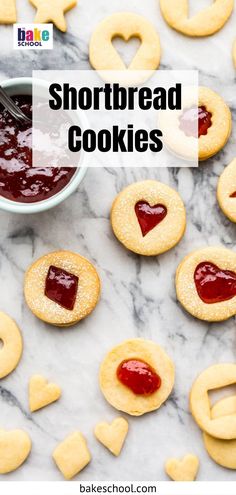 heart shaped shortbread cookies with jam in the middle and hearts around them on a marble surface