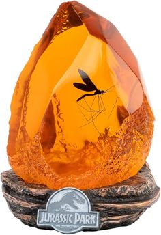 an orange glass sculpture with a dragon on it's face and the words jubasic park