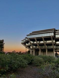 the building is made out of concrete and has many windows on each level, along with several balconies