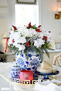 a blue and white vase filled with flowers on top of a table