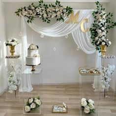 a table topped with cakes and flowers on top of a wooden floor