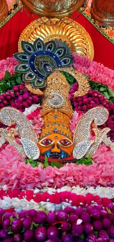 an idol is surrounded by flowers and other decorations