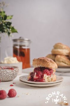 a sandwich on a plate with raspberries next to it