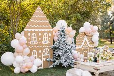 an outdoor party with balloons and gingerbread houses