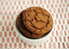 two chocolate cookies in a white bowl on a table