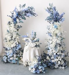 blue and white flowers are arranged around a table