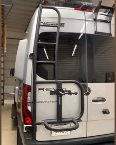 the back end of a white van with a rack on it's roof and door