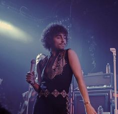 a woman holding a microphone while standing on stage