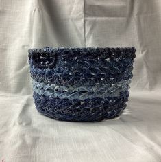 a blue basket sitting on top of a white sheet