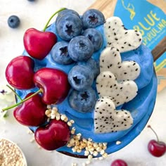 blueberries, cherries and other fruit are arranged on a plate next to a book