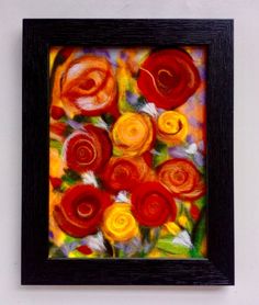 an abstract painting with red, yellow and orange flowers in a black frame on a white wall