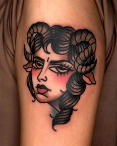 a woman's face with long hair and horns on her head is shown in this tattoo