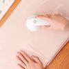 a person's hand on a mouse pad next to a keyboard