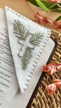 a book with a cross on it next to some flowers