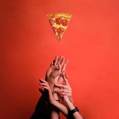 several people reaching for a slice of pizza