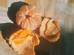 three peeled oranges sitting on top of a table