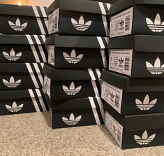 black boxes with white adidas logos stacked on top of each other