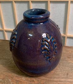 a blue vase sitting on top of a wooden table