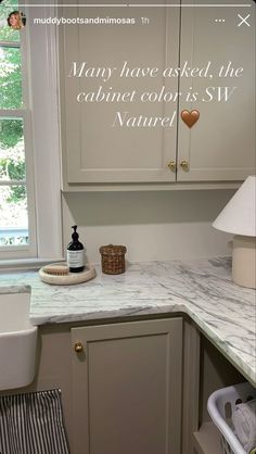 a kitchen with white cabinets and marble counter tops, along with the words many have asked the cabinet color is sw nanney