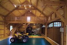 a large wooden building with two atvs parked in it