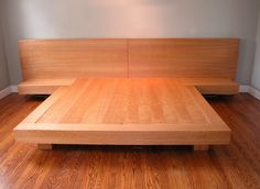 a bed that is made up with wooden headboard and foot board on the floor