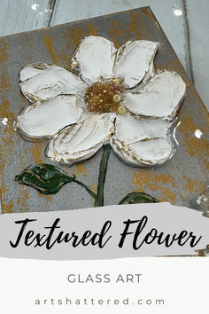 a white flower is on top of a piece of paper with text that reads, textured flower class art