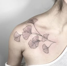 a woman with a tattoo on her shoulder has a ginkoket design on it