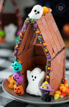 a halloween gingerbread house with ghost and pumpkins