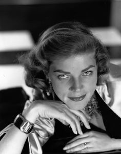 an old black and white photo of a woman with her hand on her chin, looking at the camera