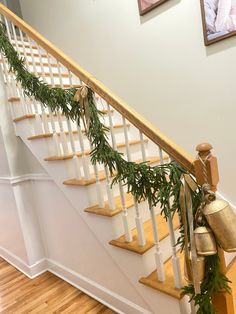 christmas garland hanging on the banister and handrails in front of stairs with bells