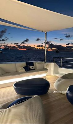 the inside of a boat with couches and tables on it at sunset or dawn