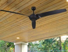 a ceiling fan mounted to the side of a wooden roof