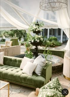 a living room filled with lots of furniture and flowers on top of a green couch