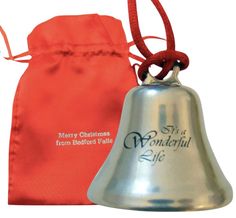 a silver bell sitting next to an orange bag