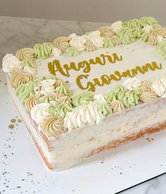 a white cake with green and yellow frosting on it's side sitting on a table