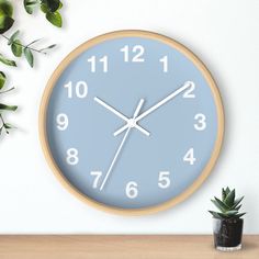 a clock on the wall next to a potted plant