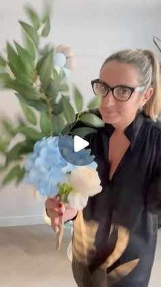 a woman in glasses holding a bouquet of flowers