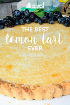 a lemon tart with blueberries on top and the words, the best lemon tart ever