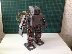 a robot that is standing up on some kind of standup with wires attached to it